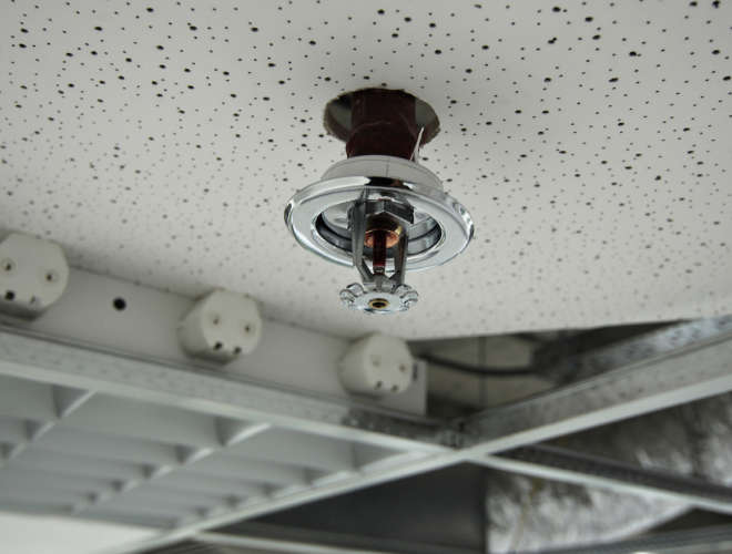 Installation process of a fire sprinkler in a ceiling - always ready for spraying water on a fire. Useful file for your brochure about security, safety and water piping systems.